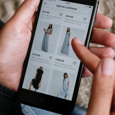 A person browsing clothing options on a smartphone for online shopping.